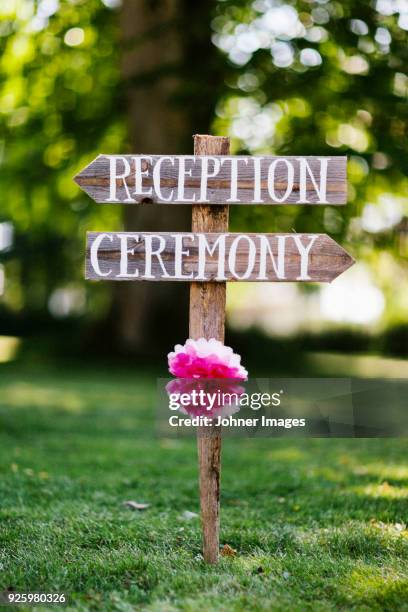 wooden reception ceremony signs with flower - wedding location stock-fotos und bilder