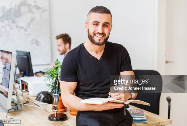 portrait of young man working at office - clock person desk stockfoto's en -beelden