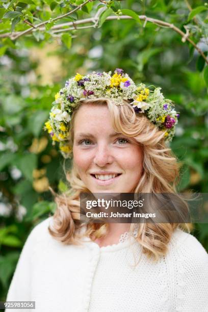 portrait of young blonde smiling woman with flower wreath on head - midsommar fotografías e imágenes de stock