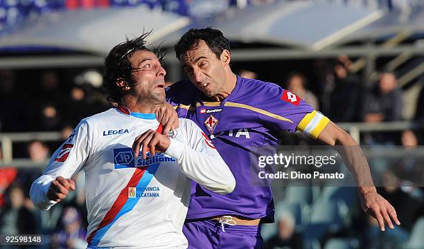 Gianvito Plasmati of Catania Calcio competes in the air air with Alessandro Gamberini of ACF Fiorentina during the Serie A match between ACF...