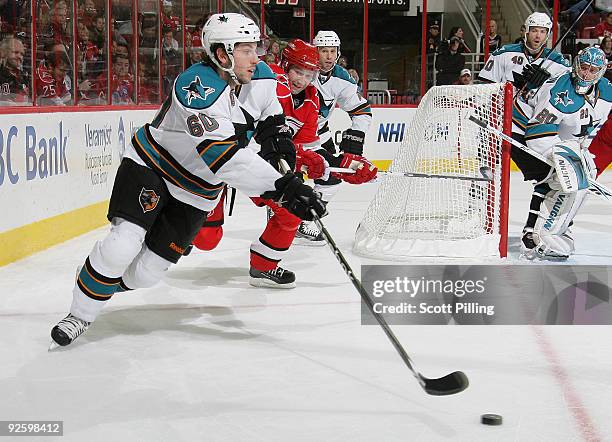 Jason Demers of the San Jose Sharks defends the puck against Erik Cole of the Carolina Hurricanes on November 1, 2009 at the RBC Center in Raleigh,...
