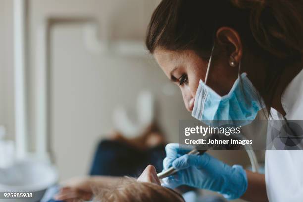 dentist at work with patient - dentiste photos et images de collection