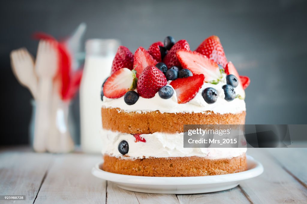 Sponge cake with strawberries, blueberries and cream