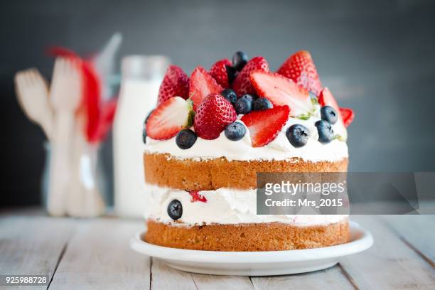 sponge cake with strawberries, blueberries and cream - natas batidas imagens e fotografias de stock