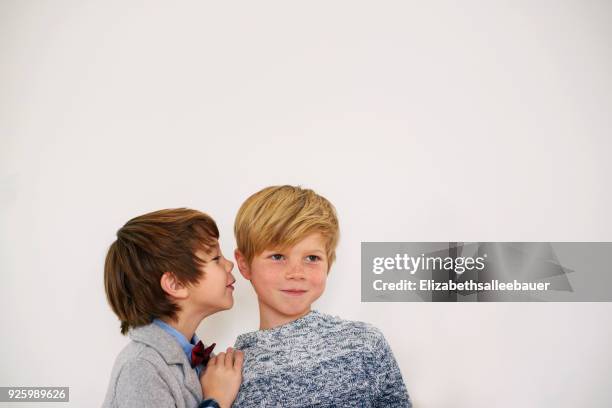 boy whispering a secret to his brother - child whispering stockfoto's en -beelden