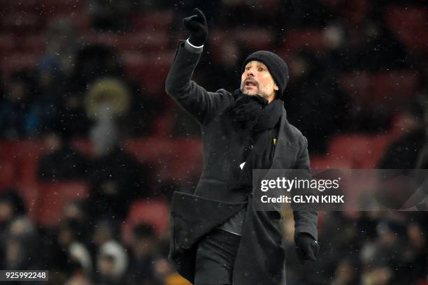 Manchester City's Spanish manager Pep Guardiola gestures on the touchline as the snow falls during the English Premier League football match between...