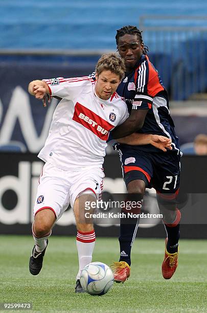 Shalrie Joseph of the New England Revolution fights for control of the ball with Logan Pause of the Chicago Fire during Game One of the Eastern...