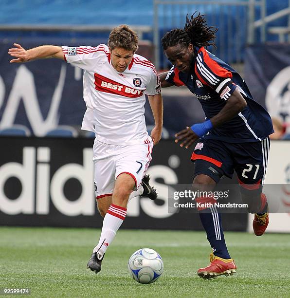 Shalrie Joseph of the New England Revolution fights for control of the ball with Logan Pause of the Chicago Fire during Game One of the Eastern...