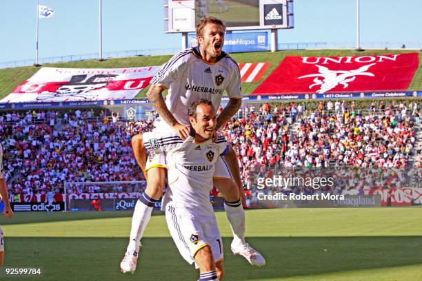 Landon Donovan and David Beckham of the Los Angeles Galaxy celebrate scoring a goal against Chivas USA during Game One of the MLS Western Conference...