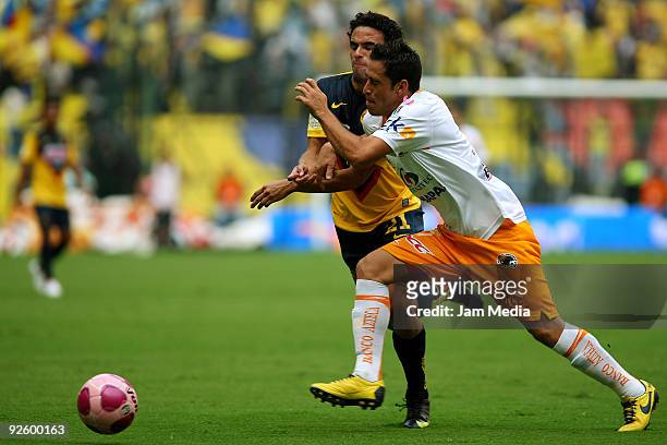 Enrique Esqueda of America vies for the ball with Oscar Razo of Jaguares during their match as part of the 2009 Opening tournament, the closing stage...