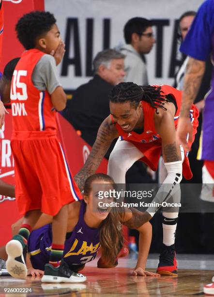 Actor Miles Brown laughs as you tube celebrity Rachel DeMita gets a hand from musician Quavo during the 2018 NBA All-Star Game Celebrity Game at Los...