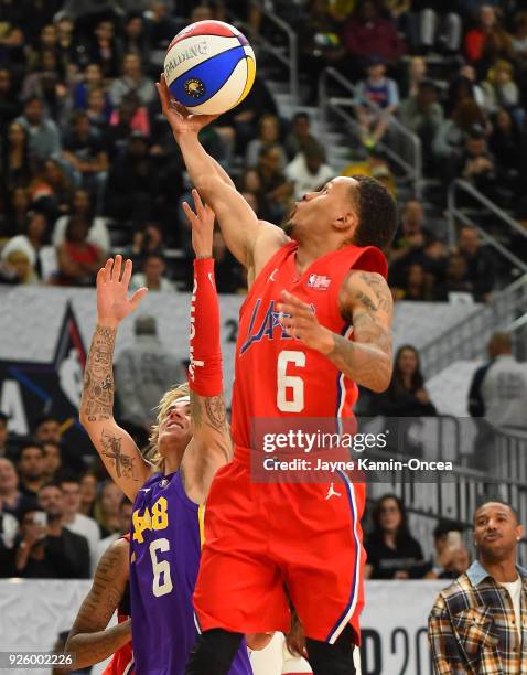 Canadian singer and songwriter Justin Bieber defends a shot by sprinter Andre DeGrasse plays during the 2018 NBA All-Star Game Celebrity Game at Los...