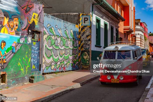 bogotá, colombia - oude volkswagen busje rijdt via een smalle, kleurrijke straat in het historische la candelaria district in de hoofdstad - la candelaria bogota stockfoto's en -beelden