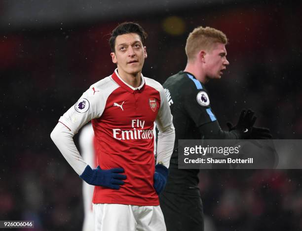Mesut Ozil of Arsenal shows his frustration in front Kevin De Bruyne of Manchester City during the Premier League match between Arsenal and...