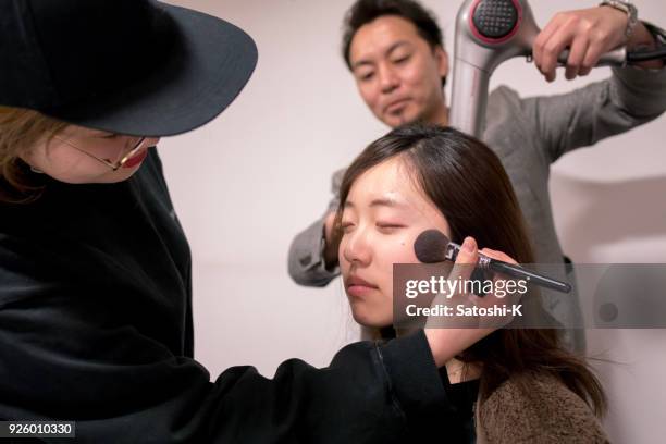 young woman having makeup applied - maquilhador imagens e fotografias de stock