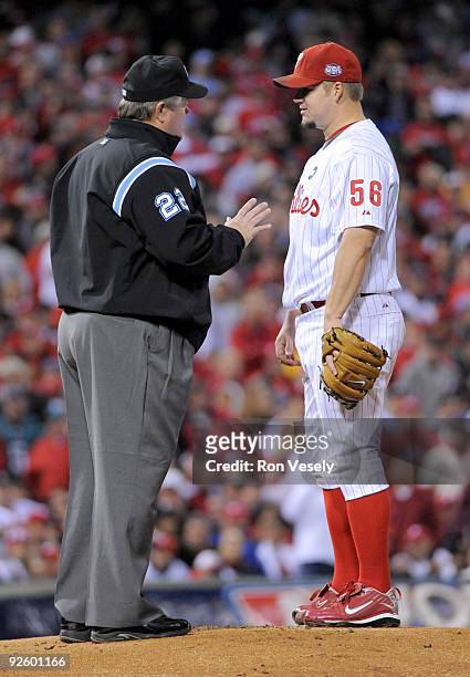 Umpire Joe West walks out to the mound to speak to Joe Blanton of the Philadelphia Phillies after Alex Rodriguez of the New York Yankees was hit by a...