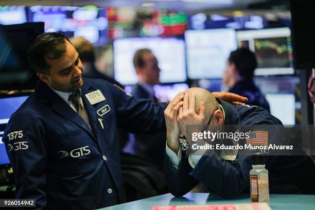 Trader is comforted by a coworker as they work on the floor of the New York Stock Exchange on March 1, 2018 in New York City. Major stock indexes...