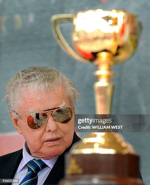 Legendary Australian horse trainer Bart Cummings, who is trying for his 13th victory, sits beside the Melbourne Cup during a press conference ahead...