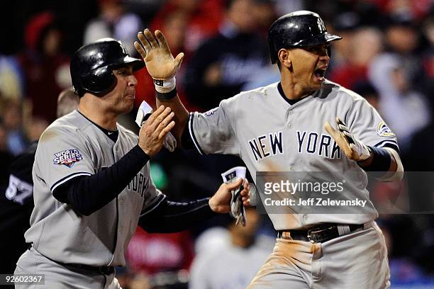 Mark Teixeira and Alex Rodriguez of the New York Yankees celebrate after they scored on a 2-run single by Jorge Posada in the top of the ninth inning...