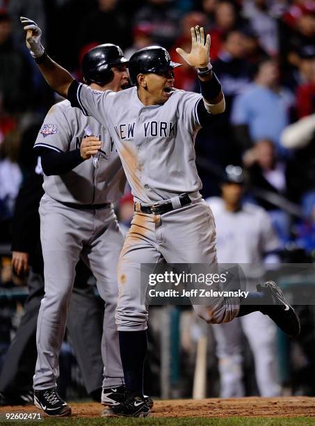 Mark Teixeira and Alex Rodriguez of the New York Yankees celebrate after they scored on a 2-run single by Jorge Posada in the top of the ninth inning...