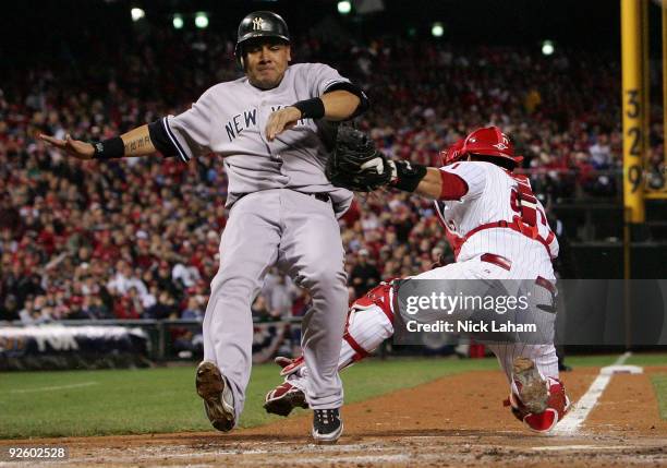 Melky Cabrera of the New York Yankees scores on a RBI single by Johnny Damon in the top of the fifth inning against catcher Carlos Ruiz of the...