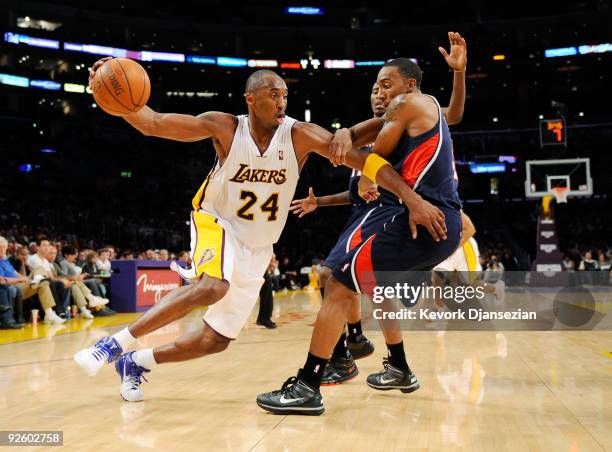 Kobe Bryant of the Los Angeles Lakers spins around Jeff Teague of the Atlanta Hawks as he drives to the basket during the NBA basketball game at...