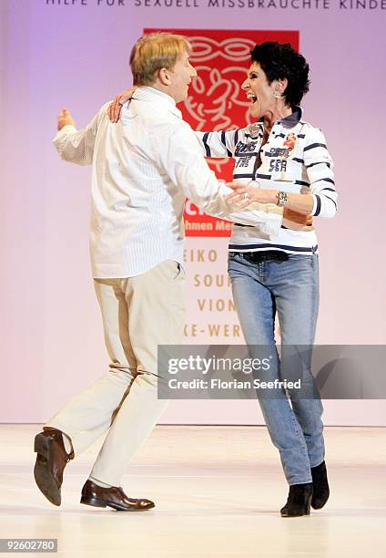 Entertainer Robert Kreis and writer Erika Berger dance on the runway at the 'Event Prominent 2009' fashion show at the Hotel Grand Elysee on November...