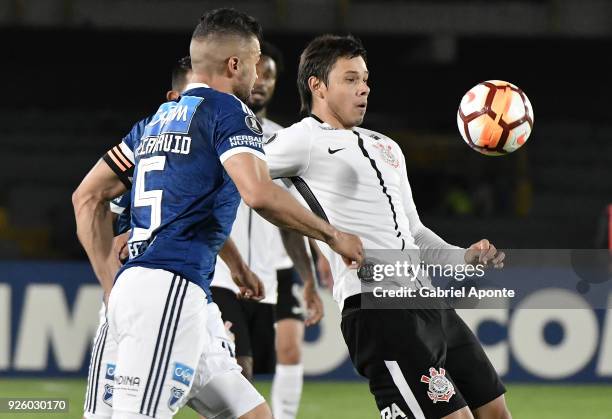 Andres Cadavid of Millonarios vies for the ball with Angel Romero of Corinthians during a Group G match between Millonarios and Corinthians as part...