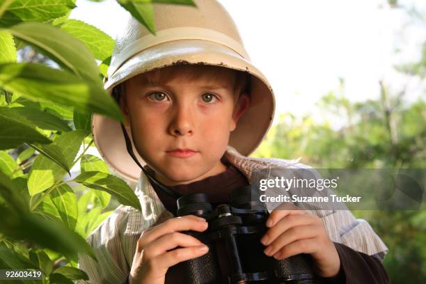 boy wearing a pith helmet holding binoculars - pith stock pictures, royalty-free photos & images