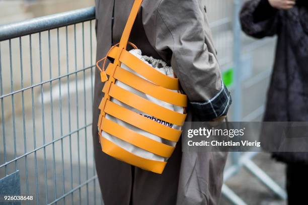 Natasha Goldenberg wearing beige wide leg pants, grey coat, Paco Rabanne bag, puffer jacket is seen outside Ann Demeulemeester on March 1, 2018 in...