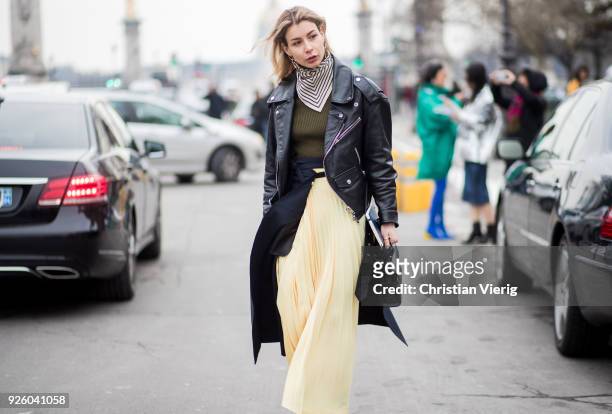 Irina Lakicevic wearing leather jacket, yellow skirt, boots is seen outside Paco Rabanne on March 1, 2018 in Paris, France.