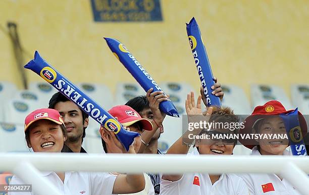 Chinese cricketers wave as they wait for the start of the fourth One Day International between India and Australia at the Punjab Cricket Association...