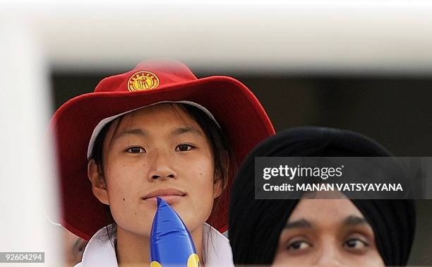 Chinese cricketer waits for the start of the fourth One Day International between India and Australia at the Punjab Cricket Association stadium in...