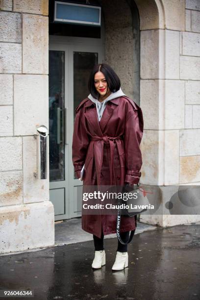 Tiffany Hsu, wearing a bordeaux trench and Off White black and white bag, is seen in the streets of Paris before the Chloe show during Paris Fashion...