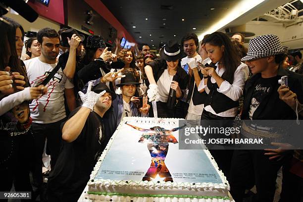 Lebanese Michael Jackson fans cut a cake with his film's poster design at a movie theatre in Beirut before the premiere of "This Is It" in the...