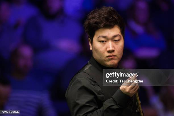 Yan Bingtao of China chalks the cue during his fourth round match against Matthew Stevens of Wales on day four of 2018 ManBetX Welsh Open at...