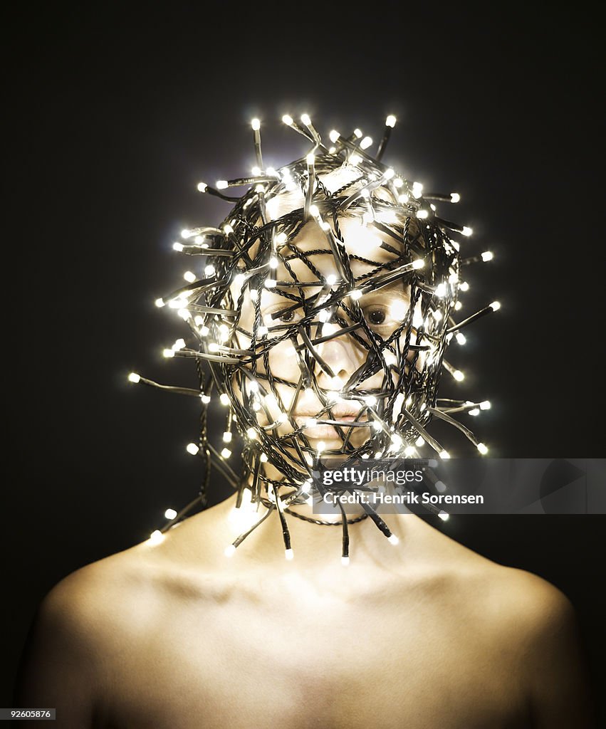  Female head wrapped in lit fairy lights