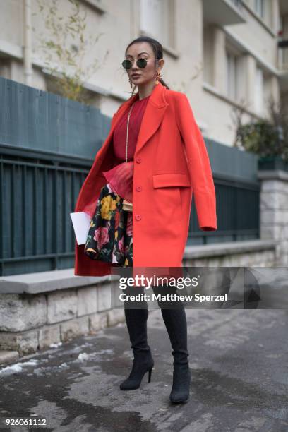 Guest is seen on the street attending Carven during Paris Fashion Week Women's A/W 2018 Collection wearing a pastel orange coat, floral pattern skirt...