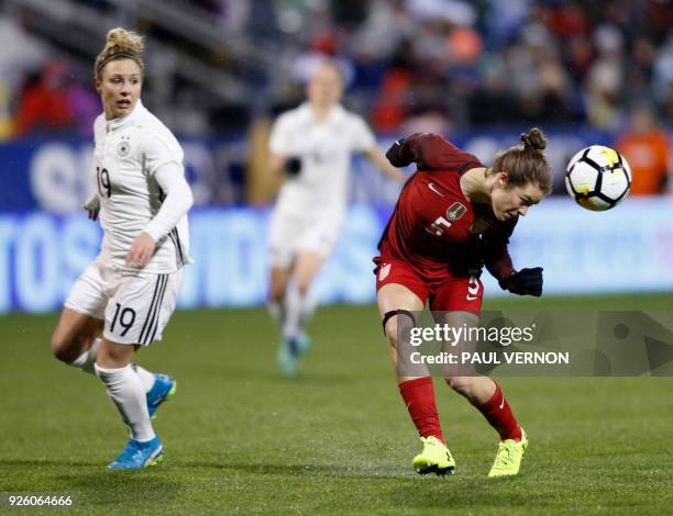 United States defender Kelley O'Hara heads the ball away from Germany forward Svenja Huth during the first half of their SheBelieves Cup match at...