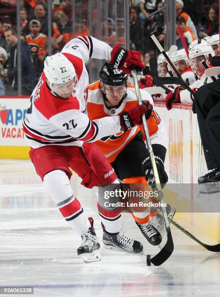 Jori Lehtera of the Philadelphia Flyers battles for control of the loose puck along the boards with Brett Pesce of the Carolina Hurricanes on March...