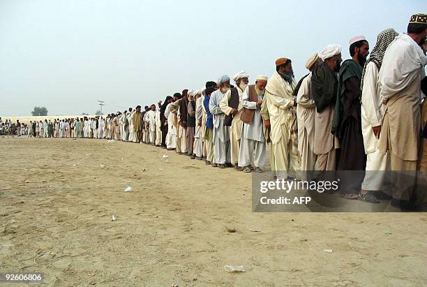 Internally displaced tribesmen, fleeing from military operations against Taliban militants in South Waziristan, queue for aid at a distribution point...