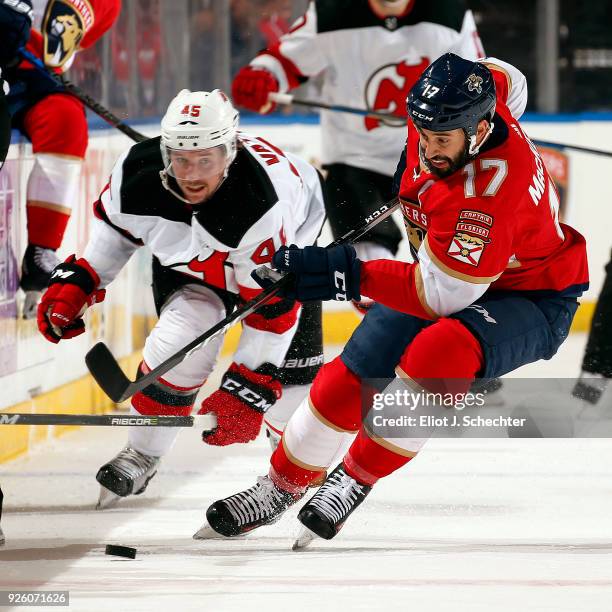 Derek MacKenzie of the Florida Panthers skates for possession against Sami Vatanen of the New Jersey Devils at the BB&T Center on March 1, 2018 in...