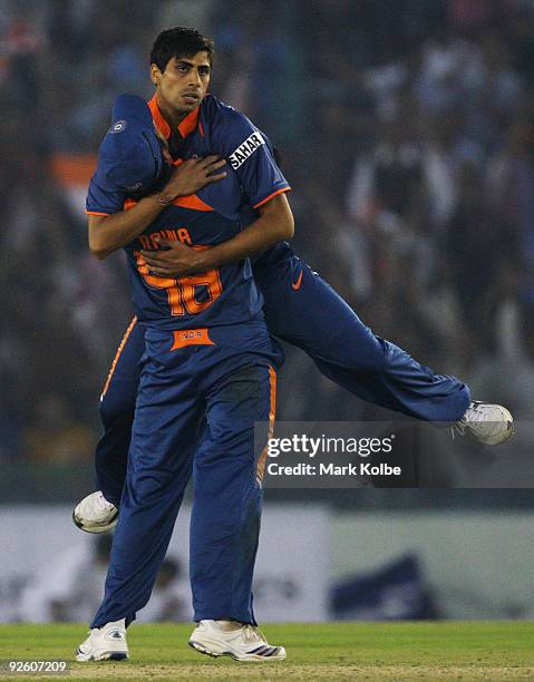 Ashish Nehra of India is congratulated by Suresh Raina of India after running out Cameron White of Australia during the fourth One Day International...