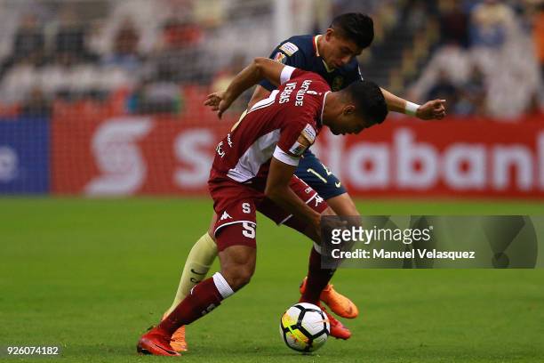 Joe Corona of America struggles for the ball against Johan Venegas of Saprissa during the match between America and Saprissa as part of the round of...