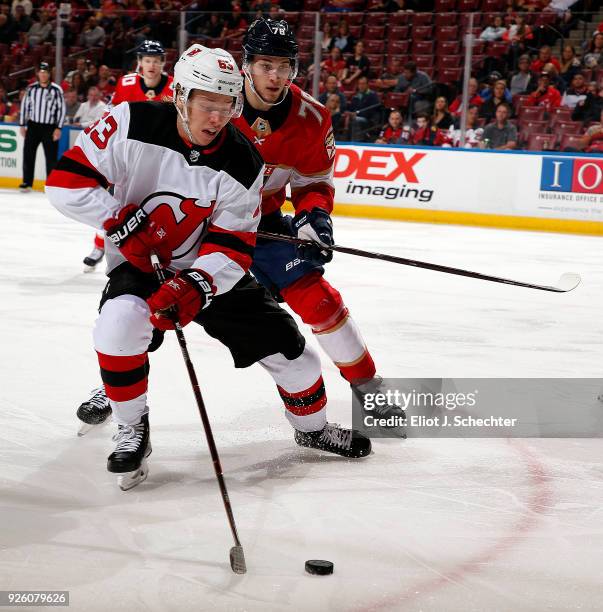 Jesper Bratt of the New Jersey Devils skates with the puck against Maxim Mamin of the Florida Panthers at the BB&T Center on March 1, 2018 in...