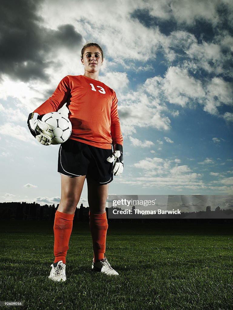 Female soccer goalkeeper standing on field