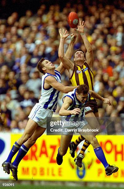 John Barker of Hawthorn attempts to mark the ball while Leigh Colbert of the Kangaroos, attempts to spoil the mark, during the round 12 match of the...