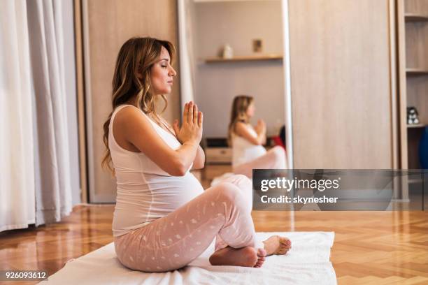 young expecting mother doing prenatal relaxation exercise at home. - prenatal yoga stock pictures, royalty-free photos & images