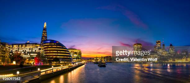 panorama, promenade on the thames, potters fields park, skyline of the city of london, gherkin, leadenhall building, walkie talkie building, more london riverside, city hall, the shard, at sunset, southwark, london, england, united kingdom - potters fields park stock-fotos und bilder