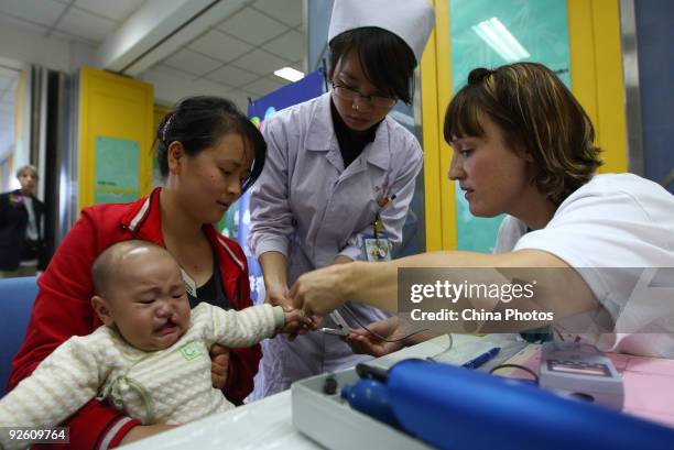 Doctor from the United States examines a child suffering from a cleft lip and palate at the Wenzhou Medical College during 'Wenzhou Happy Smile...